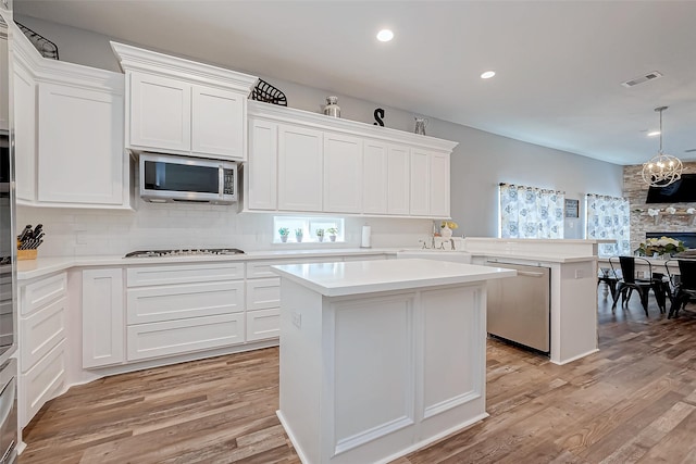 kitchen featuring white cabinetry, appliances with stainless steel finishes, a center island, and light hardwood / wood-style flooring