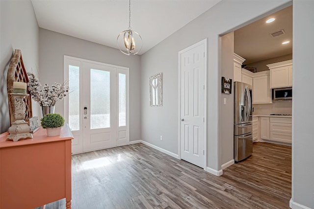 foyer entrance featuring a chandelier and light wood-type flooring