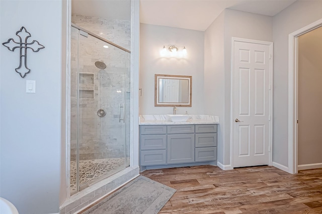 bathroom with vanity, hardwood / wood-style floors, and a shower with shower door