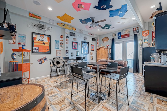 dining room with french doors, ceiling fan, beam ceiling, and sink