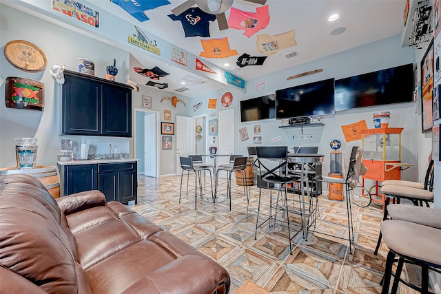 living room with ceiling fan and indoor wet bar