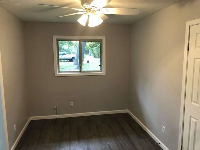 unfurnished room with dark hardwood / wood-style floors and ceiling fan