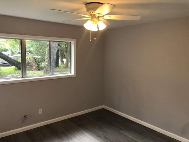 unfurnished room featuring dark wood-type flooring and ceiling fan