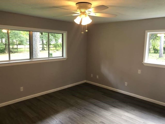 spare room featuring plenty of natural light, dark hardwood / wood-style floors, and ceiling fan