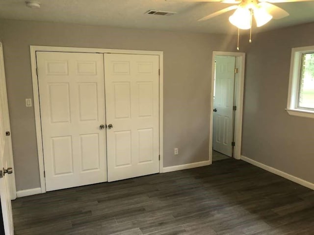 unfurnished bedroom featuring ceiling fan, dark hardwood / wood-style flooring, and a closet