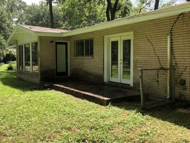 rear view of property featuring a yard and french doors