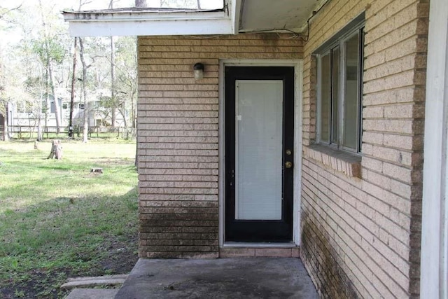 property entrance featuring a lawn