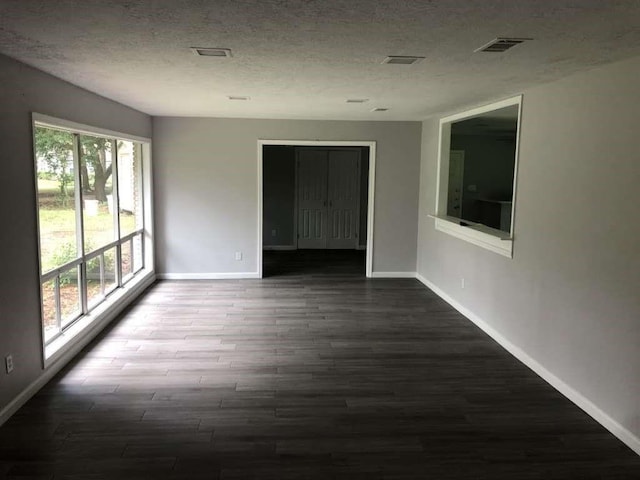 unfurnished room featuring hardwood / wood-style floors and a textured ceiling