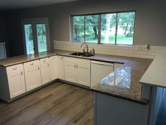 kitchen featuring dishwasher, sink, white cabinets, kitchen peninsula, and dark wood-type flooring