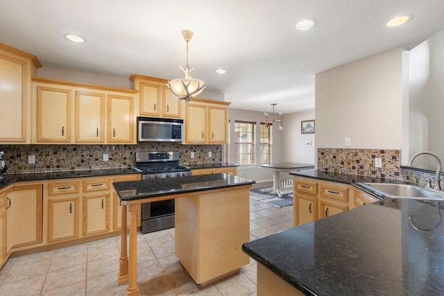 kitchen featuring sink, appliances with stainless steel finishes, hanging light fixtures, a center island, and light brown cabinets