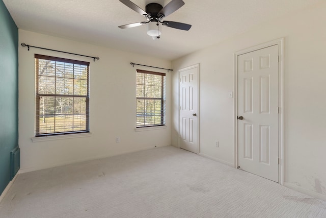 unfurnished bedroom featuring ceiling fan and light carpet