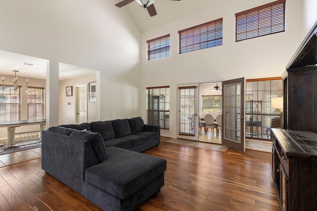 living room featuring dark hardwood / wood-style flooring, high vaulted ceiling, and ceiling fan