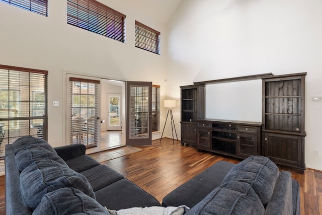 living room with dark hardwood / wood-style flooring and a towering ceiling