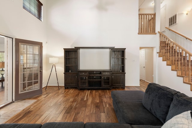 living room with hardwood / wood-style floors and a high ceiling