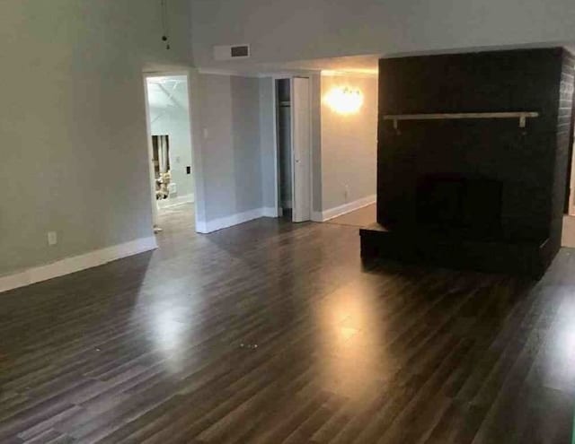 unfurnished living room with dark hardwood / wood-style flooring and a fireplace