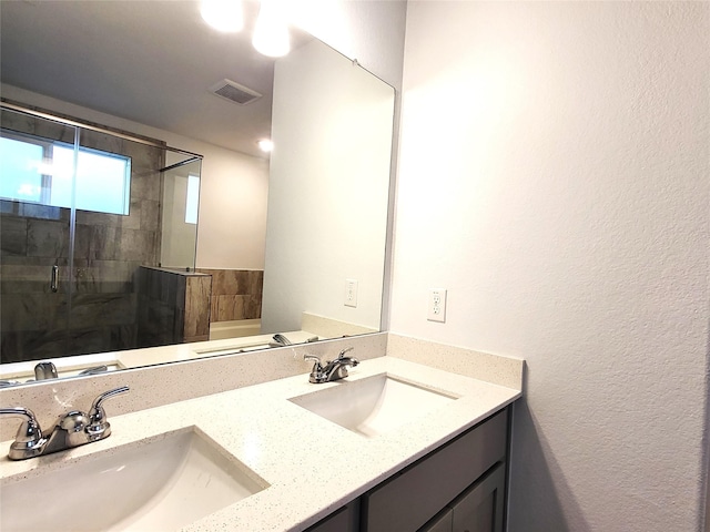 full bathroom featuring double vanity, a stall shower, a sink, and visible vents