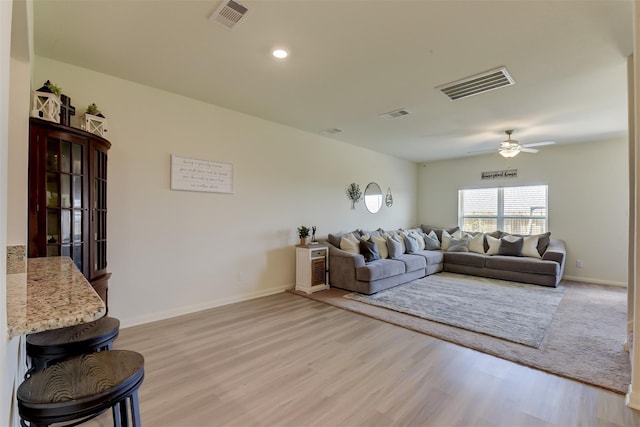 living room with light hardwood / wood-style floors and ceiling fan