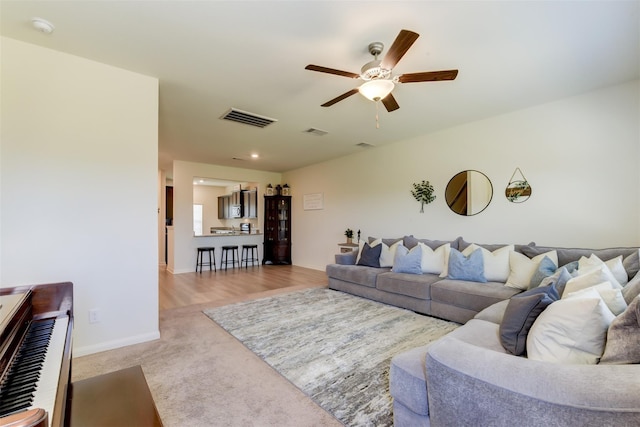 carpeted living room featuring ceiling fan