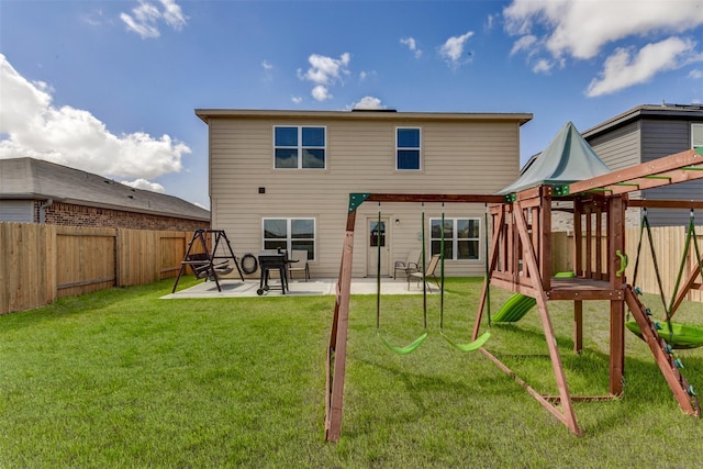 rear view of house with a playground, a yard, and a patio area