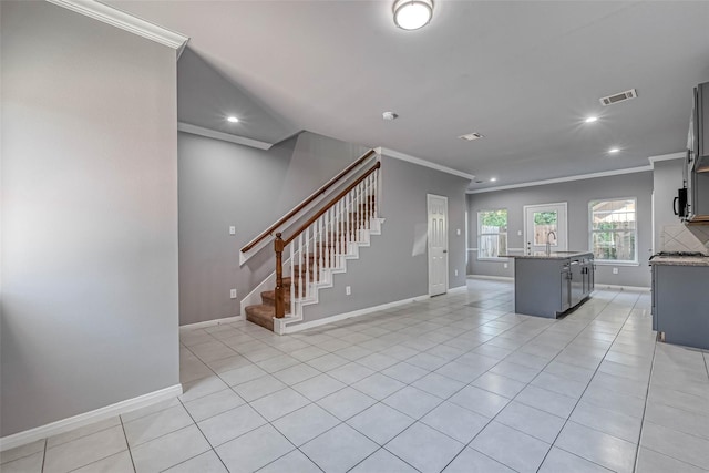 kitchen featuring ornamental molding, sink, a center island with sink, and light tile patterned floors