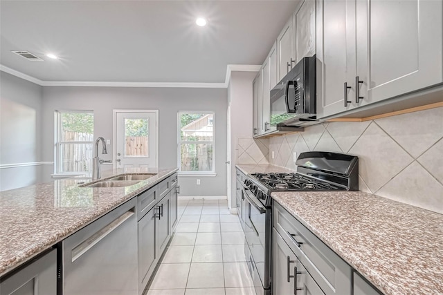 kitchen featuring stainless steel appliances, ornamental molding, sink, and tasteful backsplash