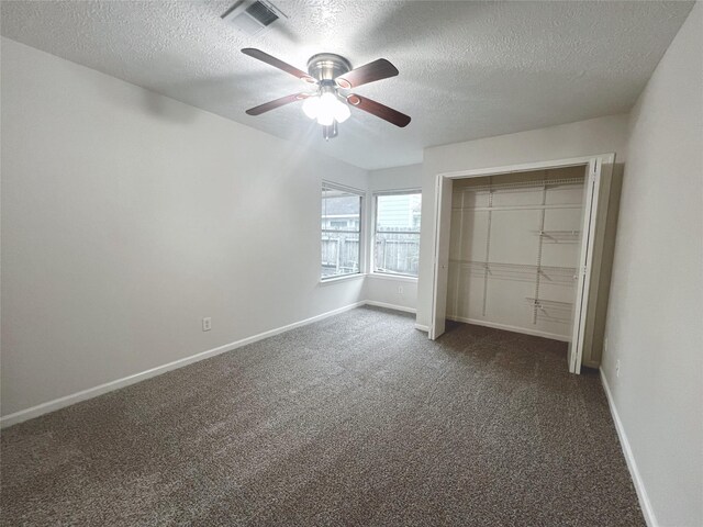 unfurnished bedroom featuring dark carpet, a textured ceiling, ceiling fan, and a closet