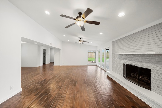 unfurnished living room featuring dark hardwood / wood-style floors, ceiling fan, lofted ceiling, and a fireplace