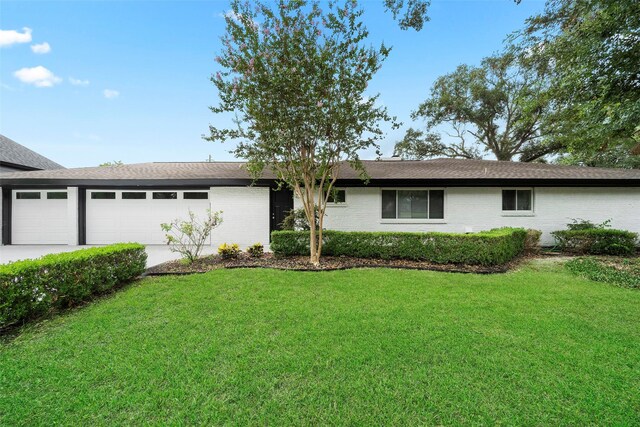 ranch-style home with a garage and a front yard