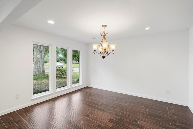 unfurnished room with dark wood-type flooring and a chandelier