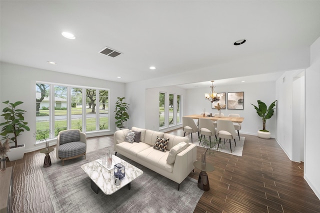 living room with dark wood-type flooring and a chandelier