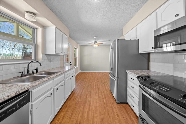 kitchen featuring white cabinetry, appliances with stainless steel finishes, sink, and tasteful backsplash