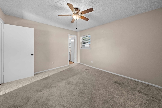 carpeted spare room featuring ceiling fan and a textured ceiling