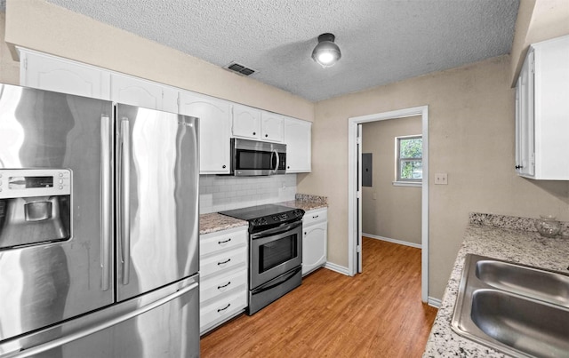 kitchen with white cabinetry, sink, backsplash, stainless steel appliances, and a textured ceiling