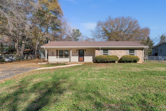 single story home featuring covered porch and a front yard