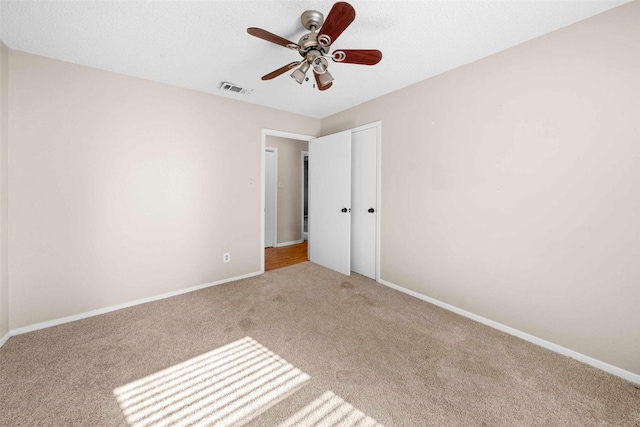 unfurnished bedroom featuring ceiling fan and light carpet