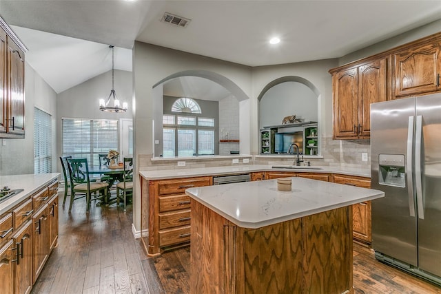 kitchen featuring dark hardwood / wood-style floors, tasteful backsplash, sink, a center island, and stainless steel refrigerator with ice dispenser