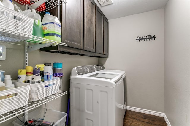 laundry area featuring cabinets, dark wood-type flooring, and independent washer and dryer