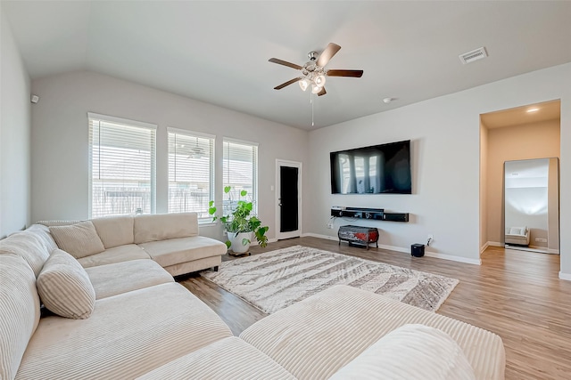 living room featuring vaulted ceiling, light hardwood / wood-style floors, and ceiling fan