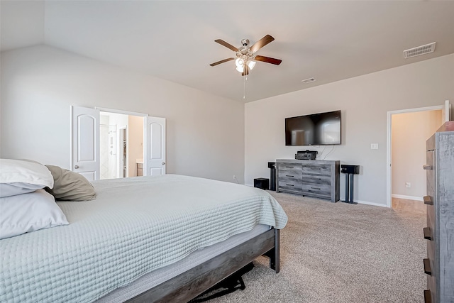 bedroom with ceiling fan, ensuite bath, vaulted ceiling, and light carpet