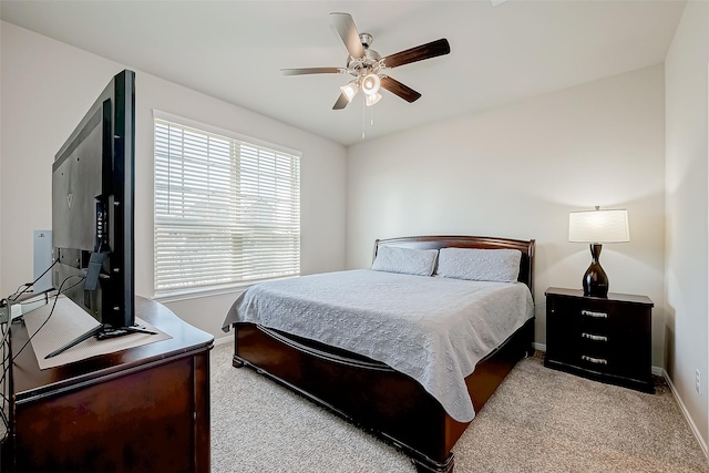 bedroom featuring multiple windows, light colored carpet, and ceiling fan