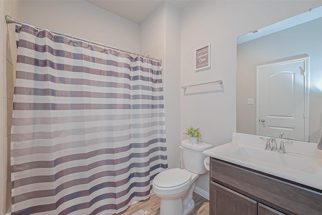 bathroom featuring wood-type flooring, curtained shower, vanity, and toilet