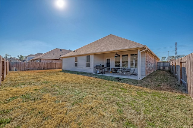 back of property featuring ceiling fan, a yard, and a patio area