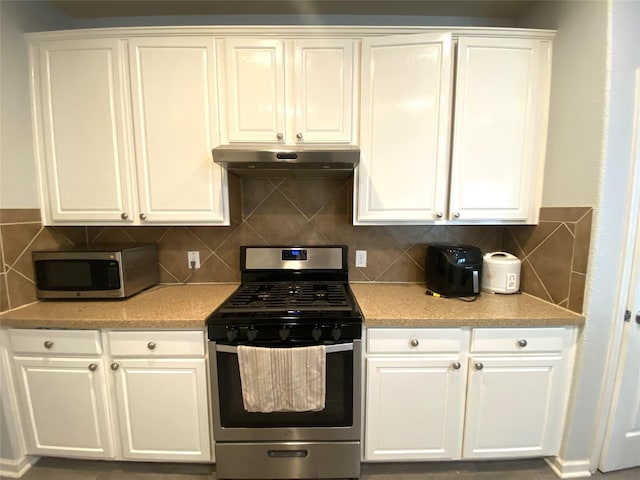 kitchen featuring stainless steel appliances, white cabinetry, and decorative backsplash