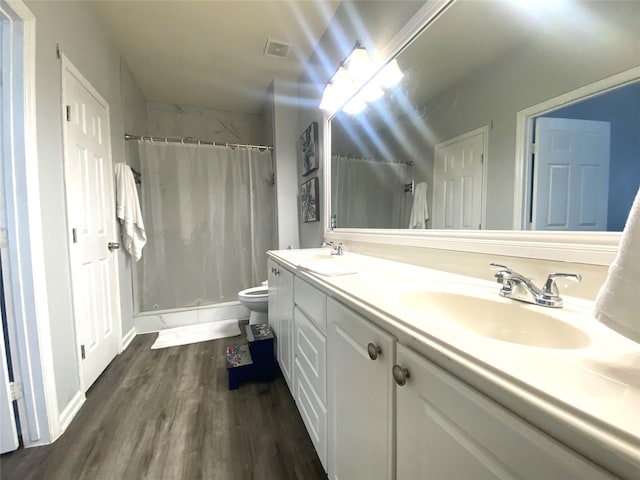 bathroom featuring vanity, wood-type flooring, toilet, and walk in shower