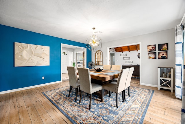 dining space featuring a notable chandelier and light wood-type flooring