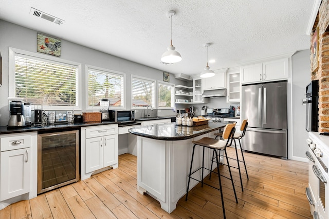 kitchen featuring white cabinets, appliances with stainless steel finishes, sink, and wine cooler