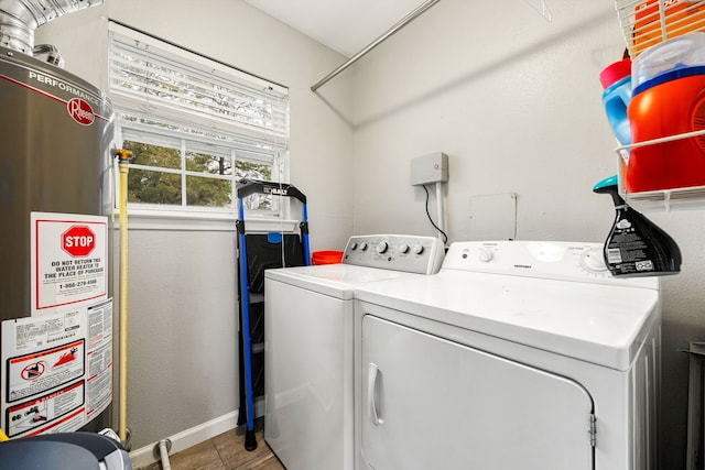 laundry room with tile patterned flooring, water heater, and washing machine and clothes dryer