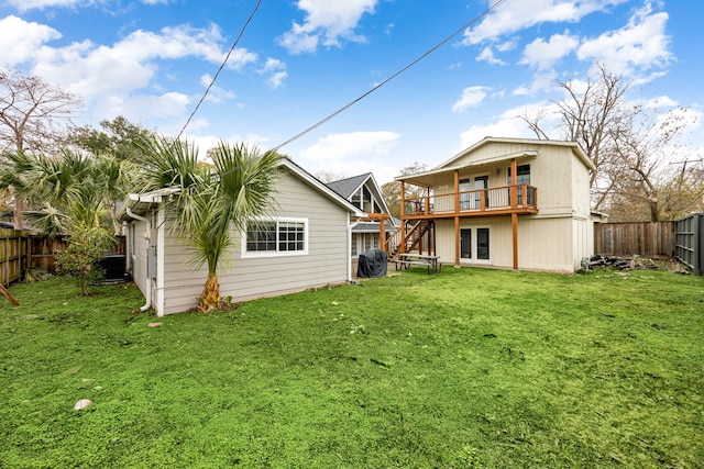 back of house with a wooden deck and a yard