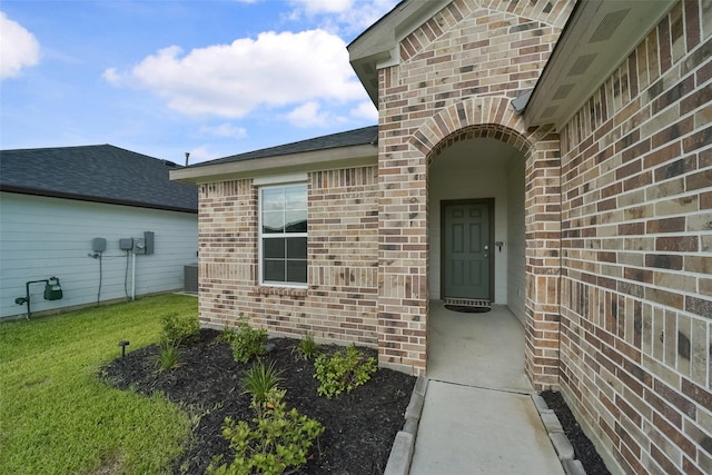 view of exterior entry with a lawn