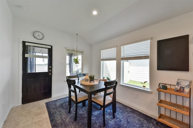 dining room with lofted ceiling and light tile patterned floors